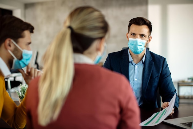 Financial advisor talking to a couple about their future investment during coronavirus pandemic