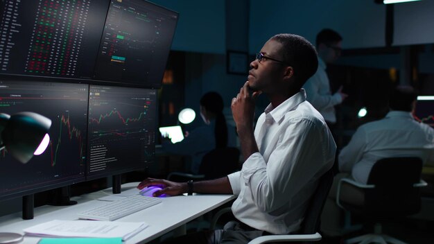 Фото Финансовый аналитик, работающий на компьютере с многомониторной рабочей станцией с акциями в реальном времени