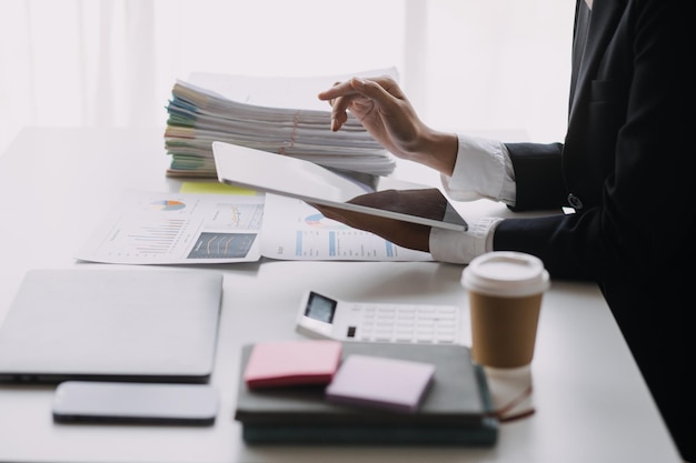 Financial analysts analyze business financial reports on a digital tablet planning investment project during a discussion at a meeting of corporate showing the results of their successful teamwork