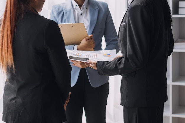 Financial analysts analyze business financial reports on a digital tablet planning investment project during a discussion at a meeting of corporate showing the results of their successful teamwork