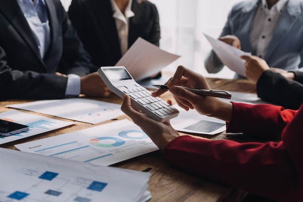 Financial analysts analyze business financial reports on a digital tablet planning investment project during a discussion at a meeting of corporate showing the results of their successful teamwork