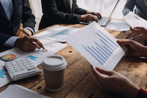 Financial analysts analyze business financial reports on a digital tablet planning investment project during a discussion at a meeting of corporate showing the results of their successful teamwork