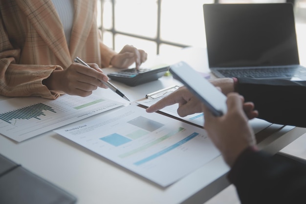 Financial analysts analyze business financial reports on a digital tablet planning investment project during a discussion at a meeting of corporate showing the results of their successful teamwork