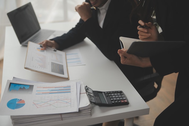 Financial analysts analyze business financial reports on a digital tablet planning investment project during a discussion at a meeting of corporate showing the results of their successful teamwork