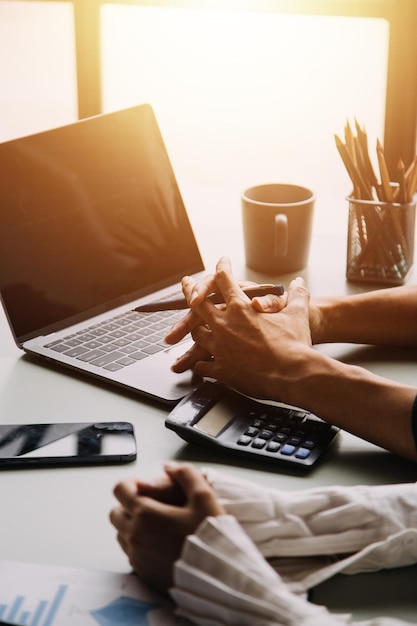 Financial analysts analyze business financial reports on a digital tablet planning investment project during a discussion at a meeting of corporate showing the results of their successful teamwork