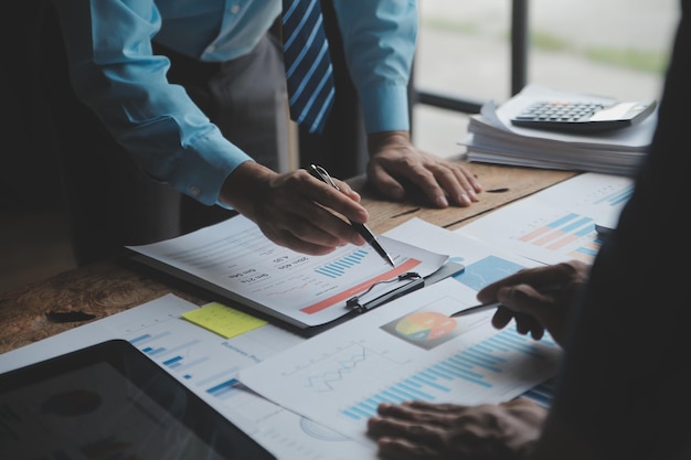 Financial analysts analyze business financial reports on a digital tablet planning investment project during a discussion at a meeting of corporate showing the results of their successful teamwork