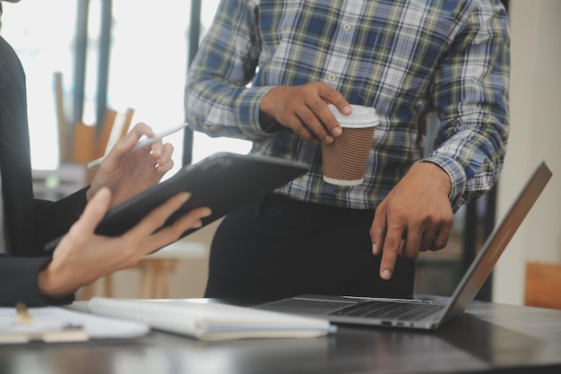 Financial analysts analyze business financial reports on a digital tablet planning investment project during a discussion at a meeting of corporate showing the results of their successful teamwork