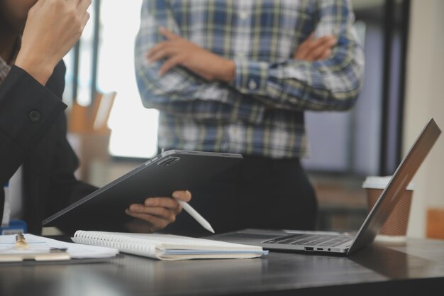 Financial analysts analyze business financial reports on a digital tablet planning investment project during a discussion at a meeting of corporate showing the results of their successful teamwork