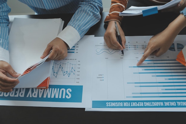 Financial analysts analyze business financial reports on a digital tablet planning investment project during a discussion at a meeting of corporate showing the results of their successful teamwork