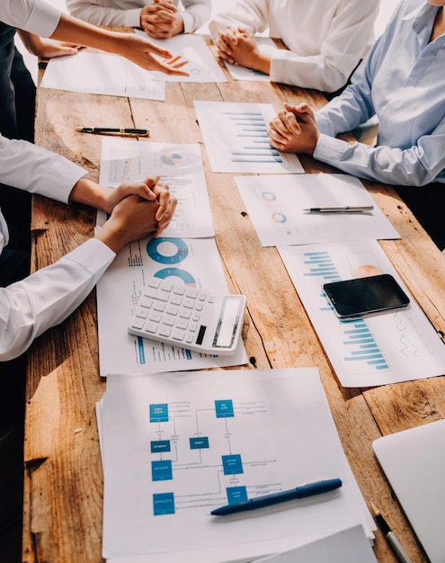 Financial analysts analyze business financial reports on a digital tablet planning investment project during a discussion at a meeting of corporate showing the results of their successful teamwork