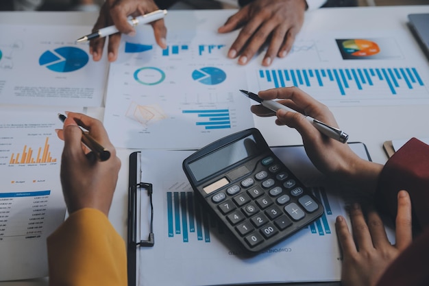 Financial analysts analyze business financial reports on a digital tablet planning investment project during a discussion at a meeting of corporate showing the results of their successful teamwork