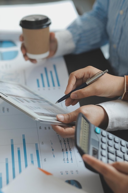 Photo financial analysts analyze business financial reports on a digital tablet planning investment project during a discussion at a meeting of corporate showing the results of their successful teamwork