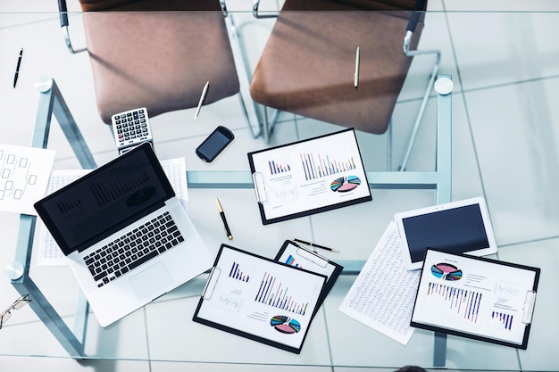 ビジネスマンの職場での財務チャート、マーケティング図、ラップトップ、電卓。