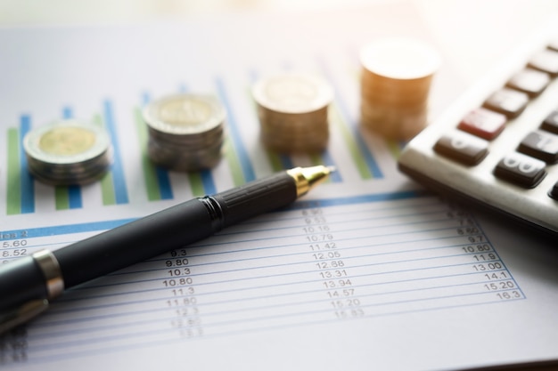 Финансовые графики на столе с ноутбуком, калькулятор, ручка и очки бизнес-концепция