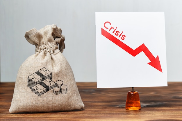 Photo financial crisis concept. a bag of money next to a falling chart