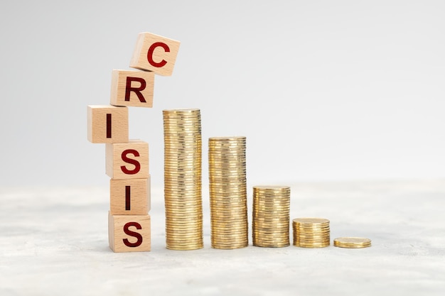 Photo financial crisis cubes with the word crisis fall on a stack of coins