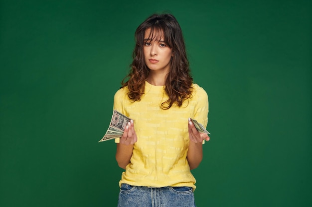 Financial crisis money problems frustrated young girl holding cash banknotes worried about debt