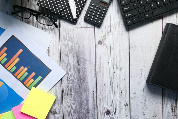 Financial graph, calculator and notepad on table.