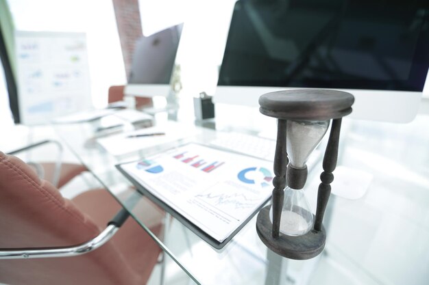 Financial graph and the hourglass on the desk