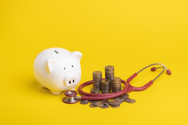 Financial for health concept The idea of saving money for healthcare Close up stethoscope and white piggy bank on yellow color and copy space Health and finance concept