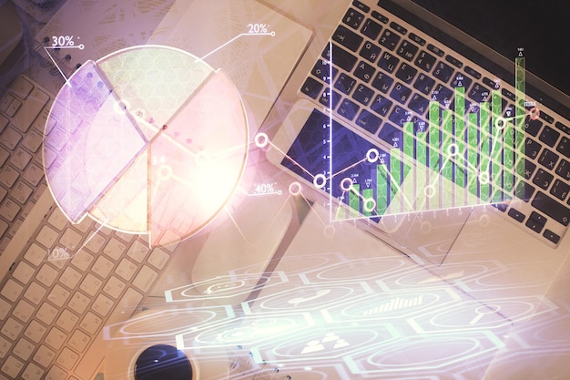 Financial market graph and top view computer on the desktop background Multi exposure Investment concept