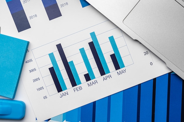 Financial paper with charts and diagrams on gray table