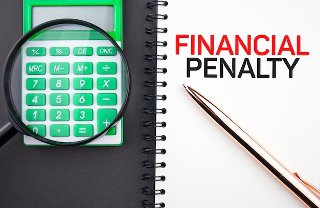 Financial penalty text concept on notepad with calculator and pen Financial business concept of imposing a fine