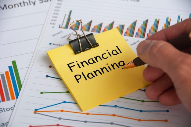 Financial planning text on yellow notepad with financial data\
analysis background financial planning concept