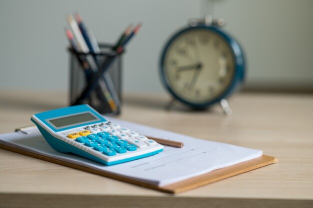 Бумага для финансового отчета и вычислительная машина на столе, офисном столе, концепции финансов и бухгалтерского учета