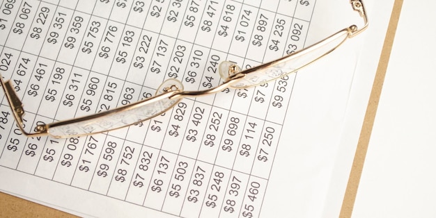 financial report pen with cap calculator glasses and paper