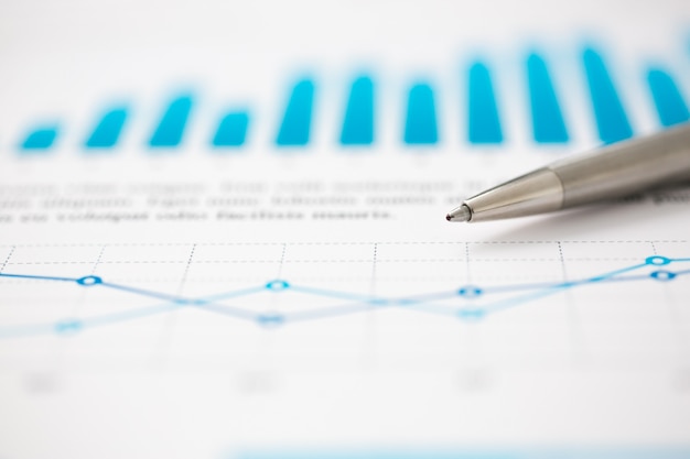 Financial statistics documents ball pen infographics at office table