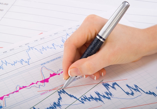 Financial statistics documents ball pen infographics at office table