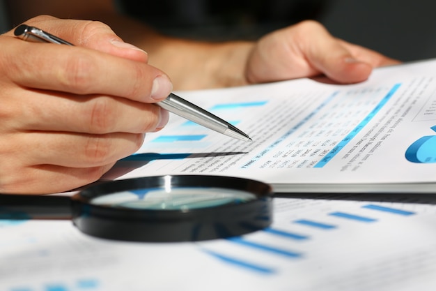 Financial statistics documents on clipboard pad at office table closeup. 