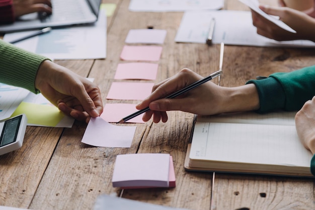 Financiële analisten analyseren zakelijke financiële rapporten over een investeringsproject voor digitale tablets tijdens een discussie tijdens een bedrijfsbijeenkomst die de resultaten van hun succesvolle teamwerk laat zien