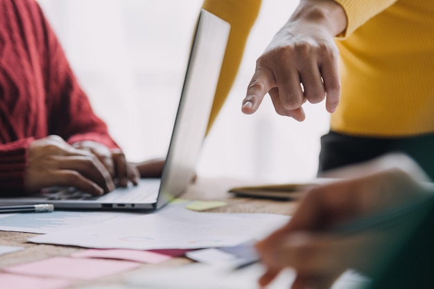 Financiële analisten analyseren zakelijke financiële rapporten over een investeringsproject voor digitale tablets tijdens een discussie tijdens een bedrijfsbijeenkomst die de resultaten van hun succesvolle teamwerk laat zien