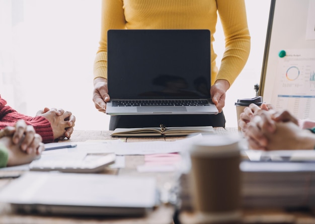 Financiële analisten analyseren zakelijke financiële rapporten over een investeringsproject voor digitale tablets tijdens een discussie tijdens een bedrijfsbijeenkomst die de resultaten van hun succesvolle teamwerk laat zien