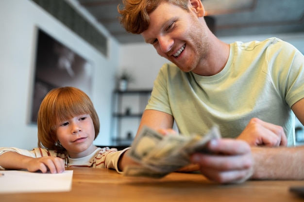 Financiële geletterdheid. Vader leert zijn zoontje financiële geletterdheid en kijkt betrokken