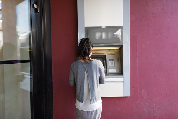 financiën, geld, bank en mensenconcept - sluit omhoog van vrouw bij geldautomaat in openlucht