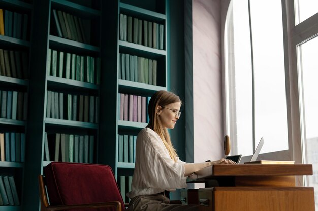 Financier woman working in an office coworking space workplace using a laptop writing a message