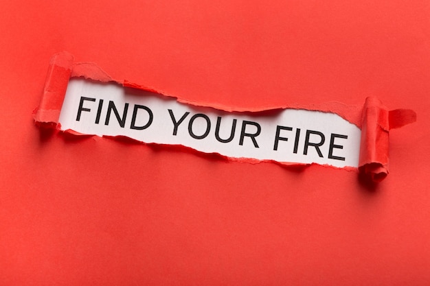 Find your fire motivation quote written on white background behind ripped red paper. Creativity, inspiration and achievement concept, copy space