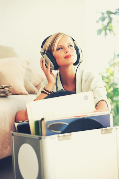 Photo find your freedom in the music a beautiful young woman listening to music while relaxing at home