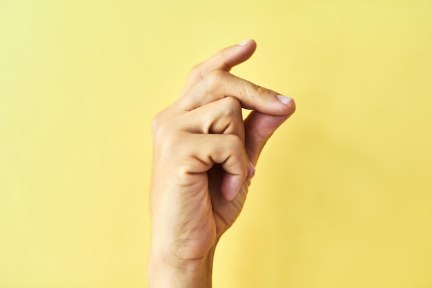 Find your groove Studio shot of an unrecognizable man snapping his fingers against a yellow background