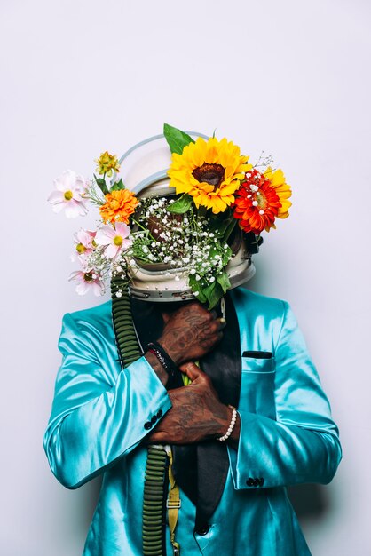 Fine art concept with man wearing a space helmet and flowers composition