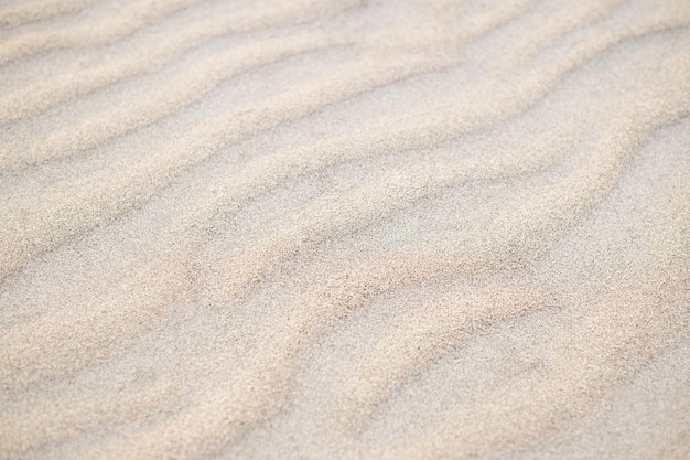 Мелкий пляжный песок на фоне летнего солнца