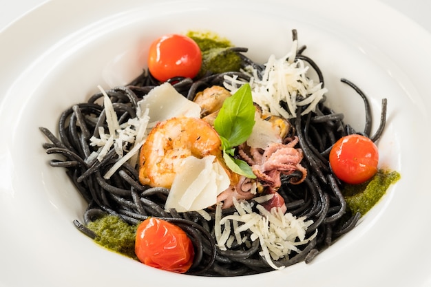 Fine cuisine food composition. Fresh black pasta with chicken and tomato.