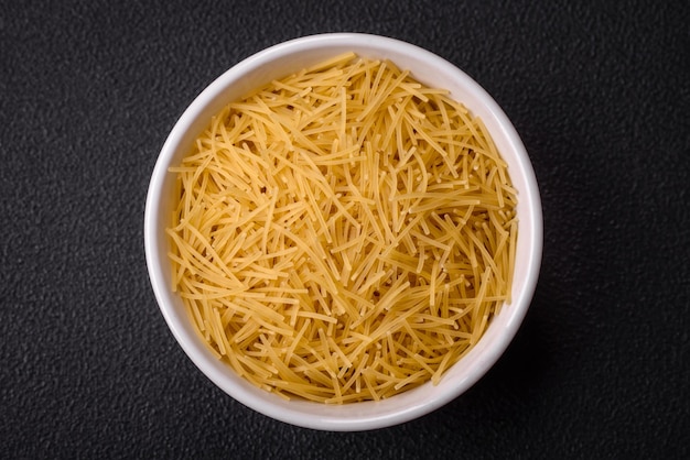 Foto la pasta fine di vermicelli è di colore giallo quando è cruda