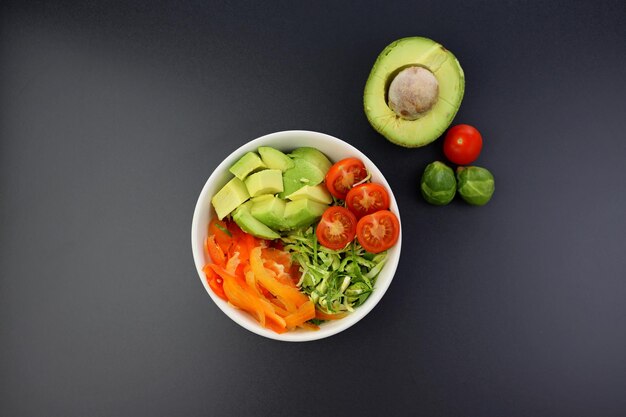 Finely chopped red and green vegetables in a round bowl on a gray background