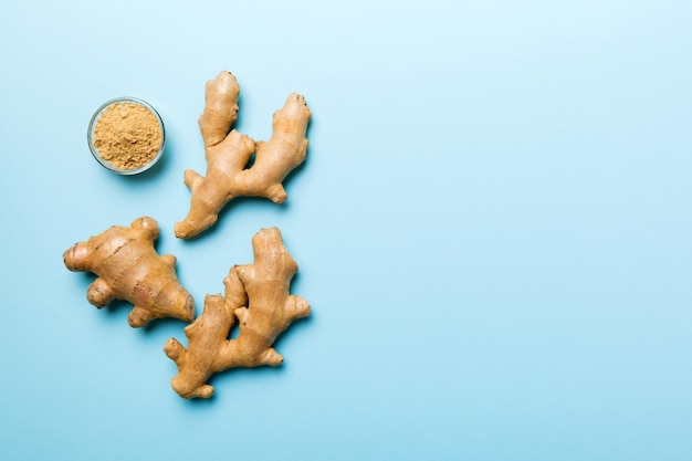 Photo finely dry ginger powder in bowl with green leaves isolated on colored background top view flat lay