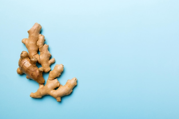 Finely dry Ginger powder in bowl with green leaves isolated on colored background top view flat lay