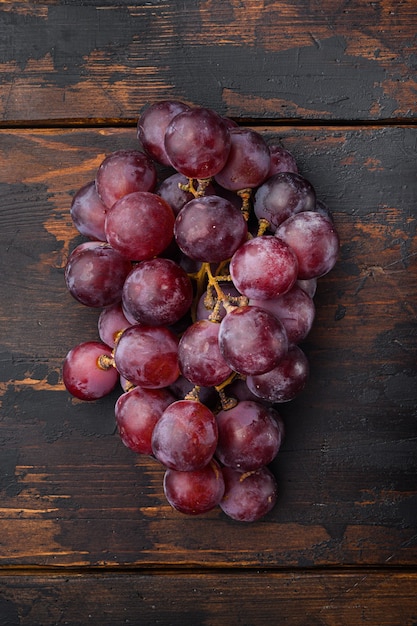 Finest natural home bunch of grapes set, dark red fruits, on old dark wooden table, top view flat lay